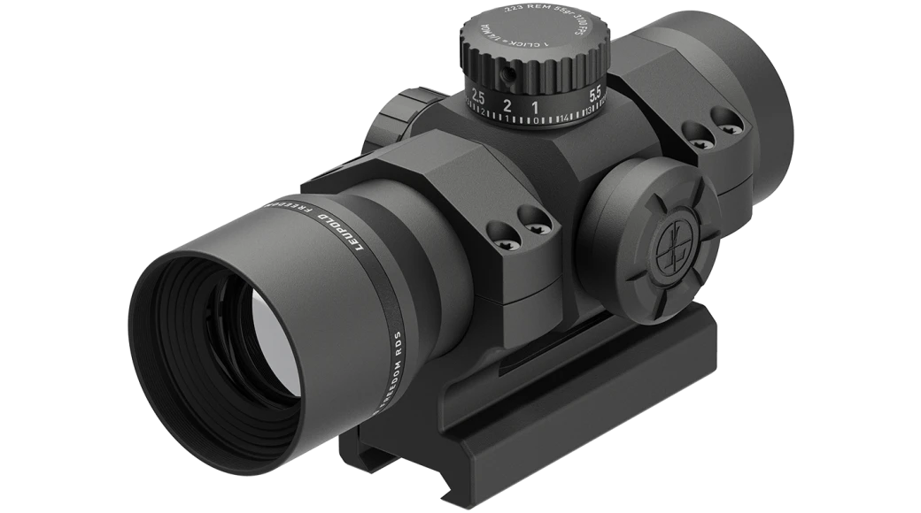 Black red dot scope with top brightness dial and wide objective lens on mount