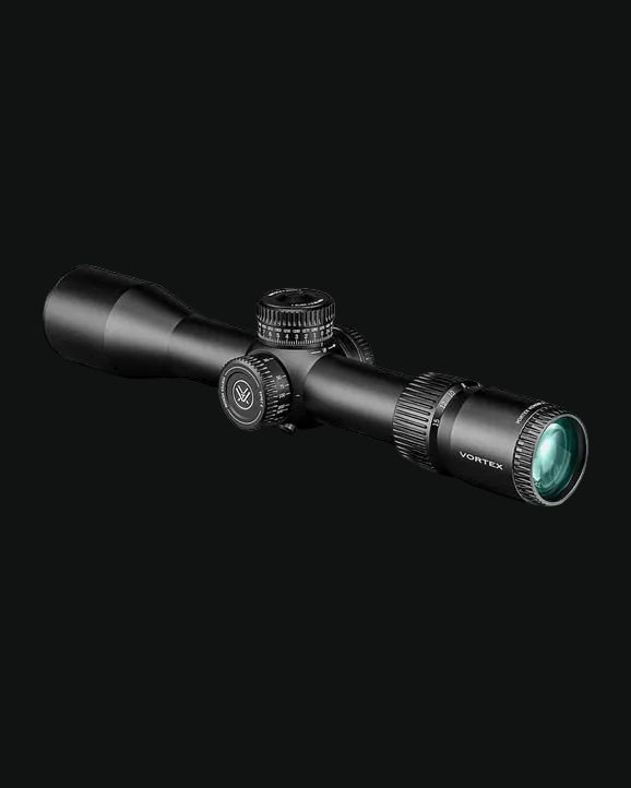 Riflescope with adjustment knobs and capped turret, wide objective lens with green tint