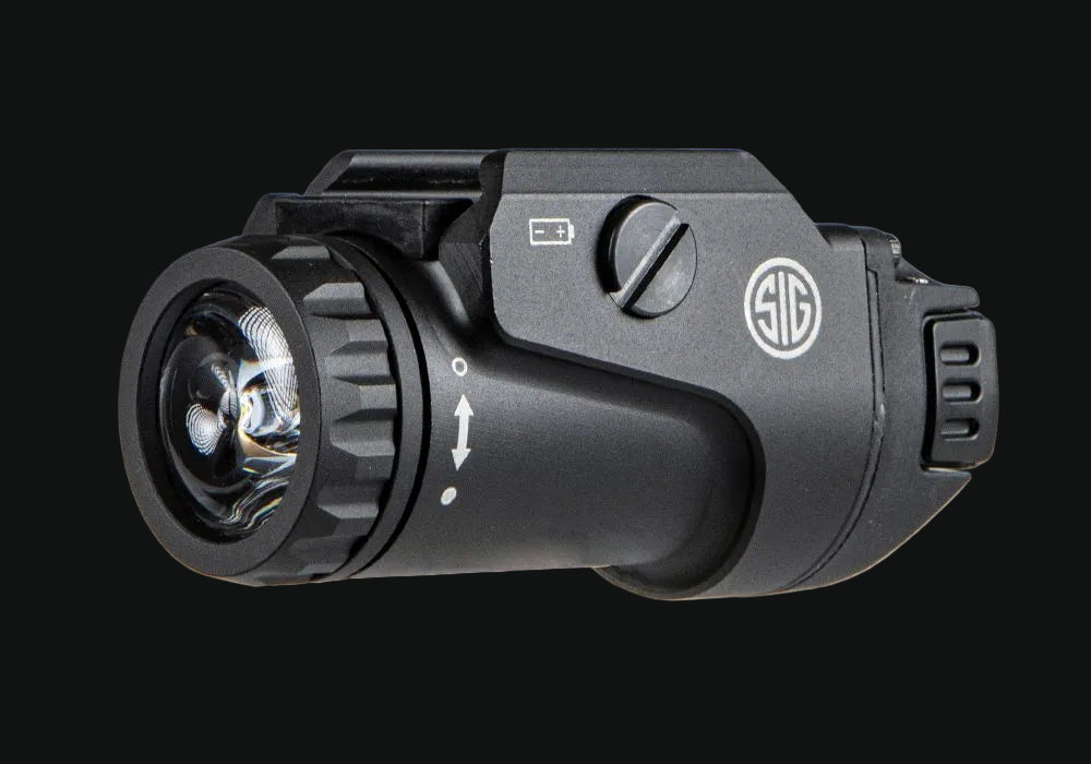Weapon light with front lens, arrow switch markings, and SIG control panel