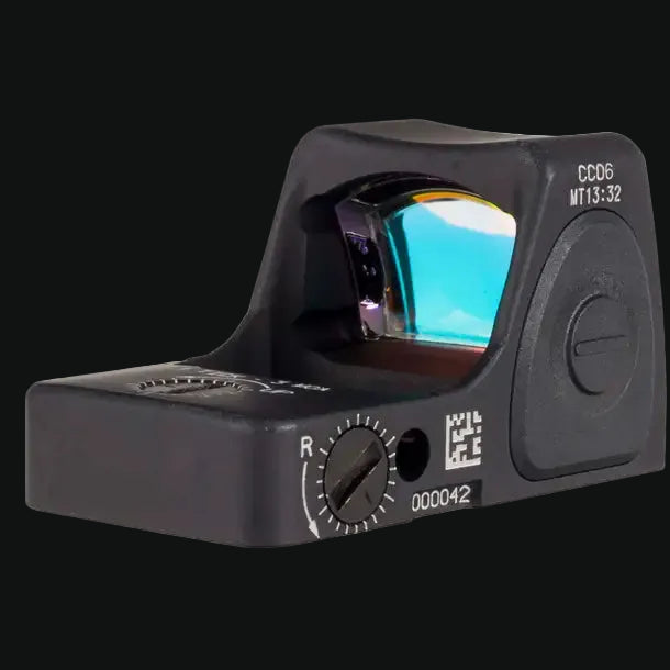 Black compact red dot sight with illuminated lens window and side elevation dial.